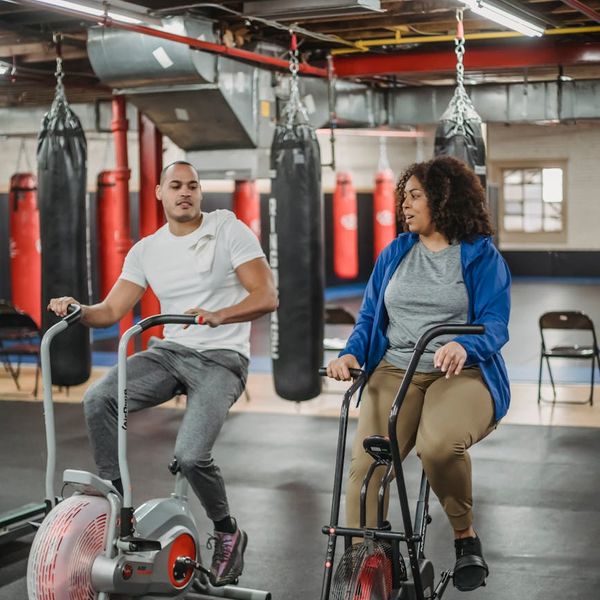 Group of people smiling after a successful cardio workout session in a bright space.